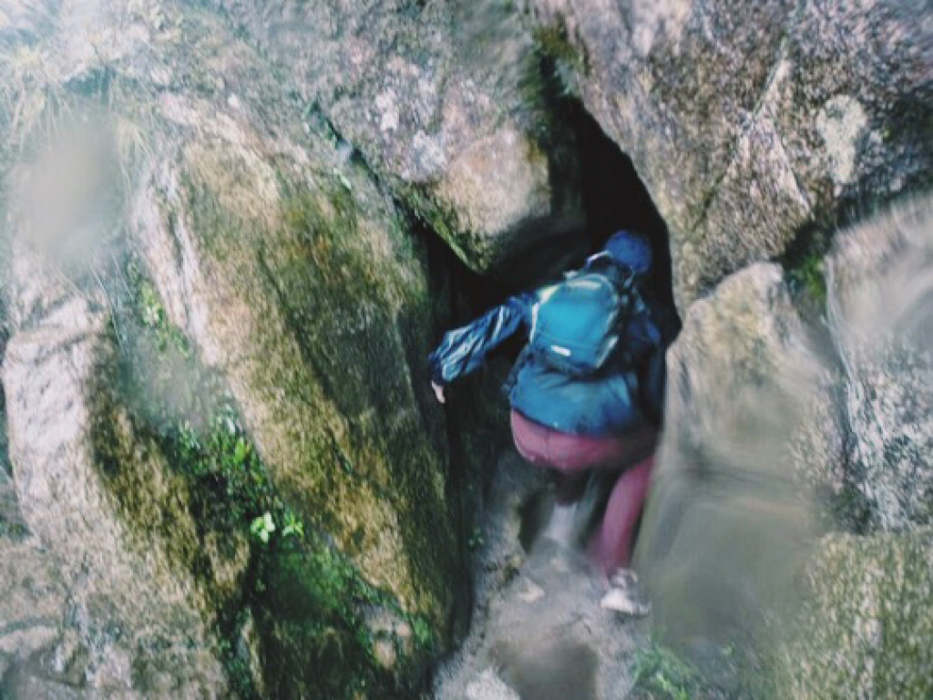 Ben climbing through cave at Huayna Picchu