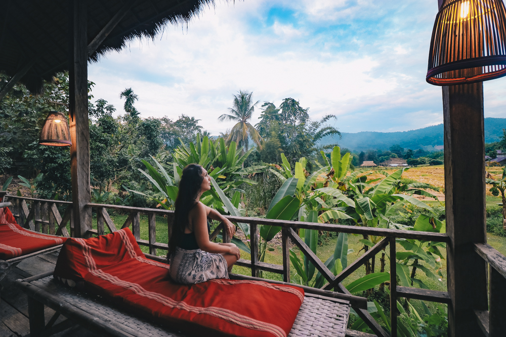 Lauren sits in Lisu Lodge by Asian Oasis: Where to stay in Chiang Mai Thailand for beautiful views