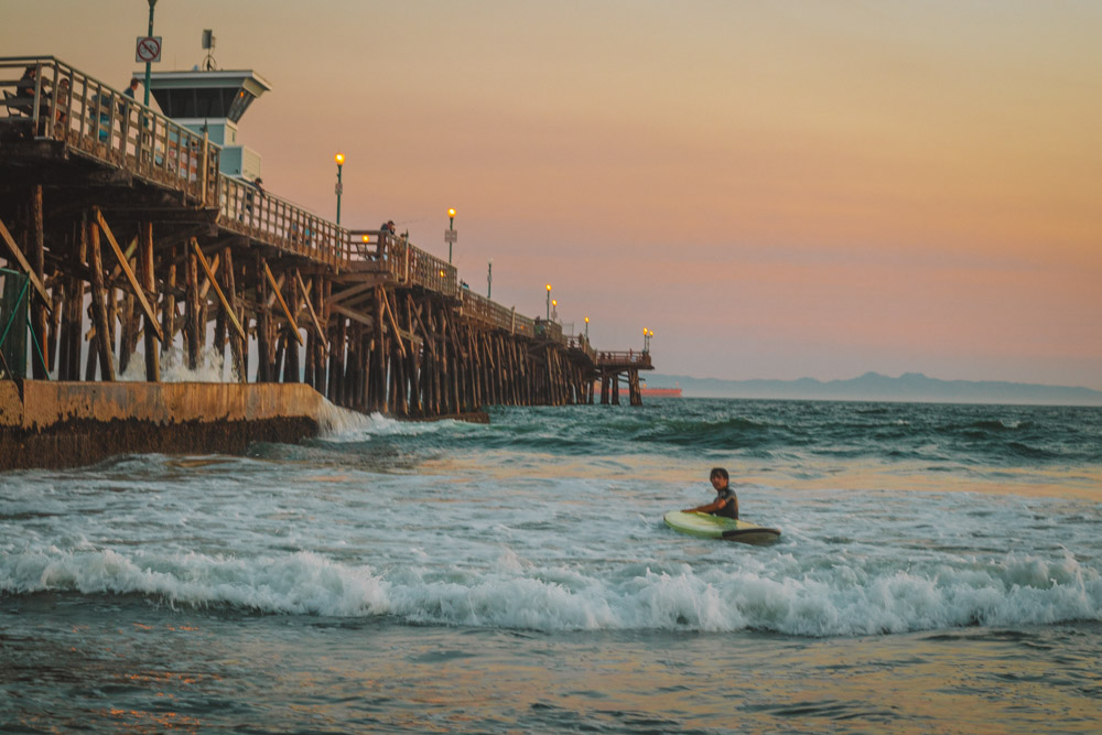 Surfer in ocean at Seal Beach. Visiting Seal Beach is one of the fun things to do in Orange County this weekend